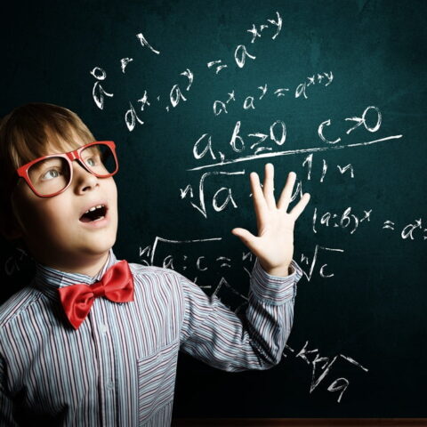 tinywow_Genius boy in red glasses near blackboard with formulas_52207535.jpg